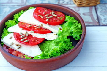 Vegan salad with pickled cheese, tomatoes and sunflower seeds