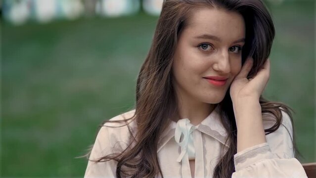 Beautiful caucasian young woman touches her lush black hair, enjoys her flirty looks. Beauty and organic hair care treatment, cosmetics, shampoo