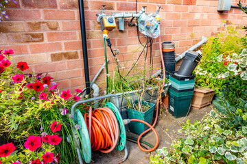 A garden watering system with hose pipes controlled by a watering computer attached to a garden tap.