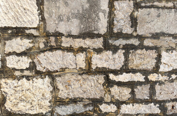An old wall where you can see the laying of bricks. Vintage background.
