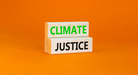 Climate justice symbol. Concept words Climate justice on beautiful wooden blocks. Beautiful orange table orange background. Business environment climate justice concept. Copy space.