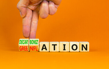 Decarbonization or greenflation symbol. Concept words Decarbonization Greenflation on cubes. Beautiful orange background. Businessman hand. Business decarbonization greenflation concept. Copy space.