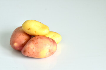 A bunch of young potatoes lie on a white background.