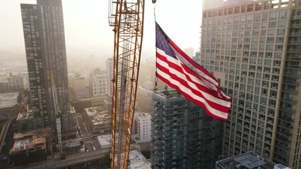 Drone footage of The American Flag flying high above New York City at sunrise