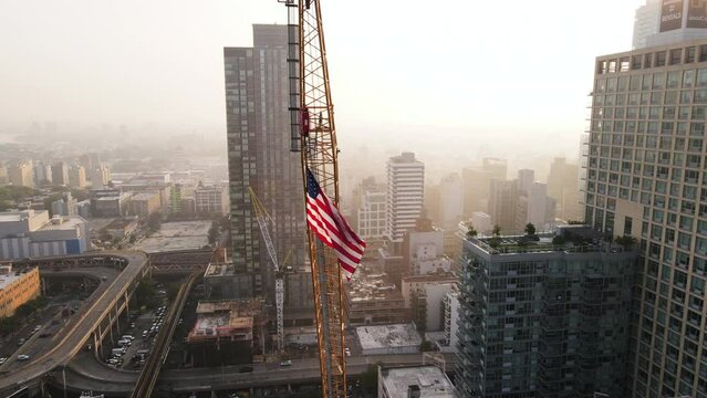 Aerial view of an Amerian Flag flying high above New York City at sunrise