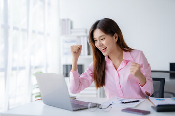 Cheerful and beautiful Asian businesswoman is excited and delighted that she achieved her goal beautifully.