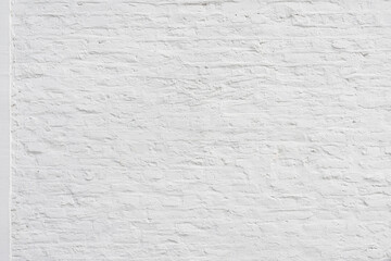 Old plaster wall painted in white with brick pattern as background
