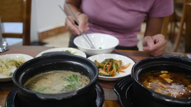 A family with young children enjoys a diverse Korean meal featuring dishes like kimchi, bulgogi, and bibimbap. This video showcases their culinary adventure and the kids' excitement 