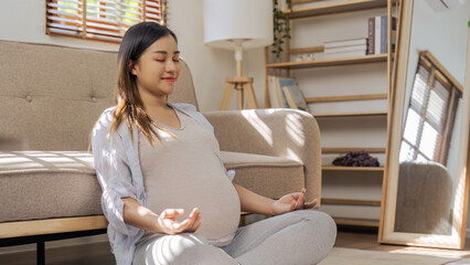 Healthy Pregnancy Yoga and Fitness. Young pregnant yoga woman and meditation in living room
