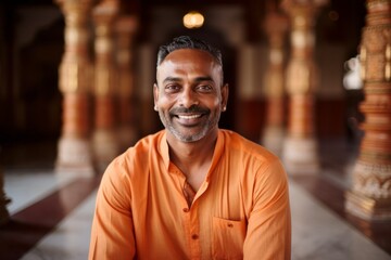 Obraz premium Medium shot portrait of an Indian man in his 40s in his 40s wearing a chic cardigan in a hindu temple ,