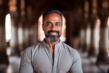 Obraz premium Medium shot portrait of an Indian man in his 40s in his 40s wearing a chic cardigan in a hindu temple ,