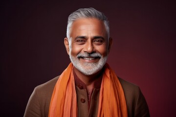 Fototapeta premium Portrait of a handsome Indian man wearing an orange scarf and smiling