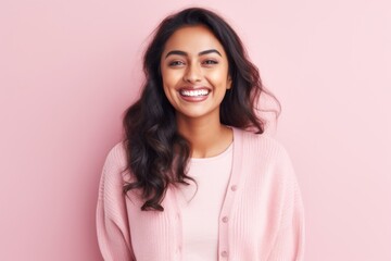 Fototapeta premium Portrait of a smiling young woman looking at camera on pink background