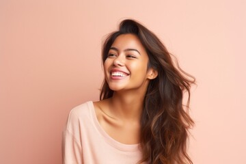 Fototapeta premium Portrait of a beautiful young asian woman smiling on pink background