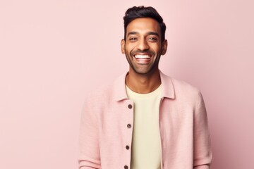 Obraz premium Portrait of a smiling young Indian man looking at camera over pink background