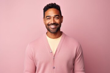 Obraz premium Portrait of handsome indian man smiling at camera isolated on pink background