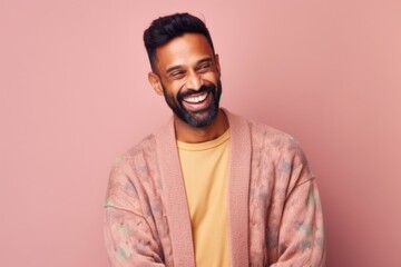 Obraz premium Portrait of a happy young indian man in a dressing gown on a pink background