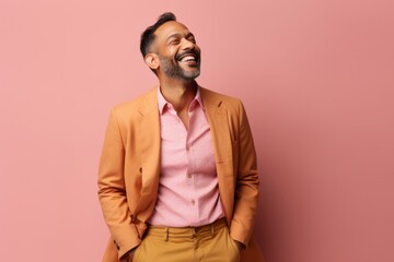 Fototapeta premium Handsome Indian man over isolated pink background laughing and looking up