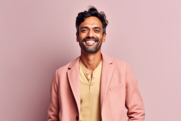 Obraz premium Portrait of a young indian man in a pink jacket on a pink background