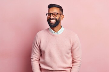Fototapeta premium Portrait of a happy indian man in pink sweater and glasses