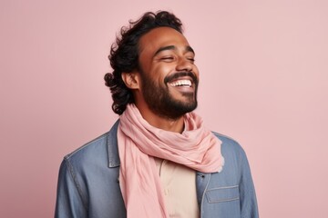 Obraz premium Portrait of a smiling young man wearing scarf and posing isolated over pink background