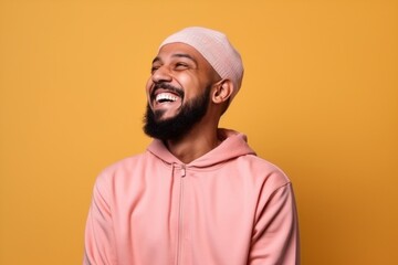 Obraz premium Young african american man wearing a pink hoodie over yellow wall laughing