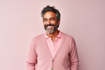 Fototapeta premium Portrait of a happy Indian man smiling at camera over pink background