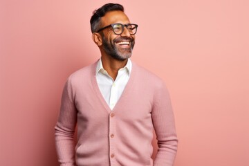 Fototapeta premium happy indian man in eyeglasses looking at camera on pink background