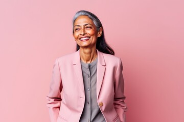 Fototapeta premium Portrait of a happy senior asian businesswoman isolated over pink background