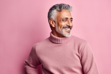 Obraz premium Portrait of a smiling Indian man in a pink sweater on a pink background