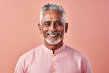 Obraz premium Portrait of a happy Indian senior man in pink shirt, isolated on pink background