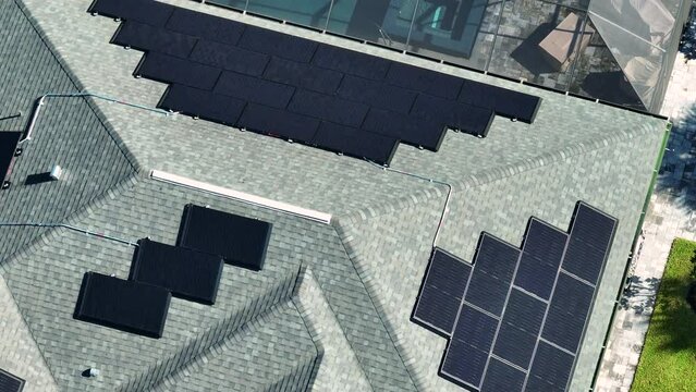 Aerial view of typical american building roof with rows of blue solar photovoltaic panels for producing clean ecological electric energy. Renewable electricity with zero emission concept