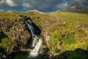 Fototapeta na wymiar Beautiful waterfall in Glenbrittle, Isle of Skye, with the Cuillin mountains in the distance