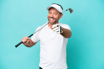 Middle age caucasian golfer player man isolated on blue background pointing front with happy...
