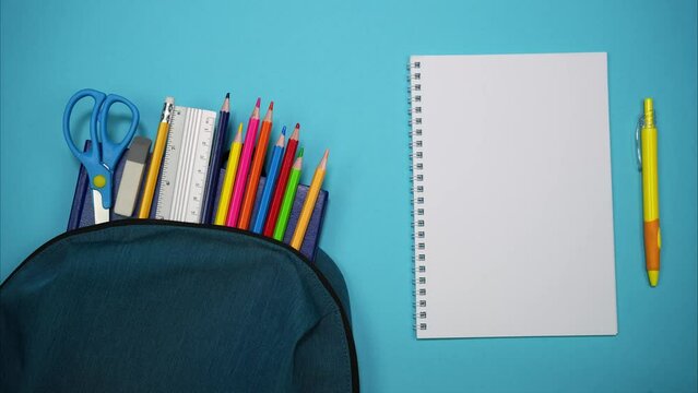From the school bag appear books, scissors, pencils and ruler. A blank sheet with a pen. Place for inscription. Stop motion