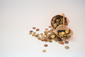 Euro money coins spilling out of a piggy bank on a white background. Savings, inflation, economy concept. 