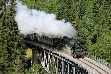 A steam locomotive driving through the Krkonoše hills