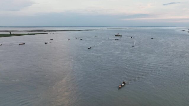 The aerial shot of boats crossing the Jamuna River in Bangladesh is a breathtaking sight. The mighty river snakes its way through the lush green landscape, carrying with it the lifeblood of the nation