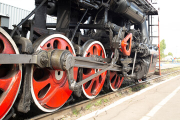 An old steam locomotive of the early 20th century on the railway track.