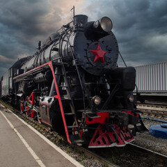 An old steam locomotive of the early 20th century on the railway track.