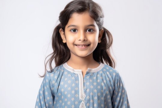 Lifestyle Portrait Of An Indian Child Female Wearing Kurta Pajama Against A White Background