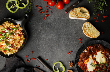 Shakshuka on a black background. Dark background with vegetables. Scrambled eggs on a weedy background. White bread, tomatoes, pepper, eggs.