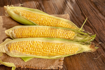 Corncobs on a brown wooden background. - 637098008