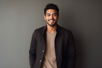 Fototapeta premium Medium shot portrait of an Indian man in his 20s in a minimalist background