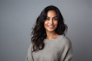 Fototapeta premium Medium shot portrait of an Indian woman in her 30s in a minimalist background