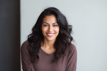 Obraz premium Lifestyle portrait of an Indian woman in her 30s in a minimalist background