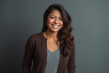 Fototapeta premium Lifestyle portrait of an Indian woman in her 30s in a minimalist background