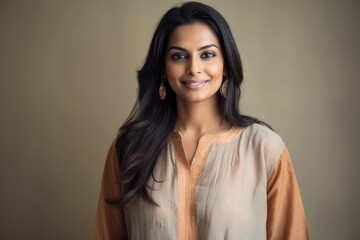 Lifestyle portrait of an Indian woman in her 30s wearing thobe or dishdasha in a minimalist background