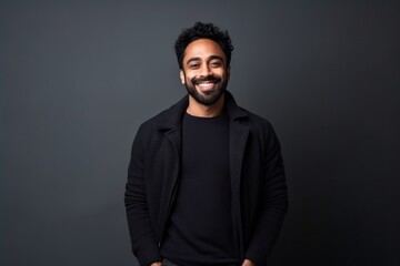 Medium shot portrait of an Indian man in his 30s in a minimalist background