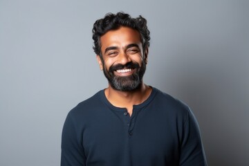 Fototapeta premium Medium shot portrait of an Indian man in his 30s in a minimalist background